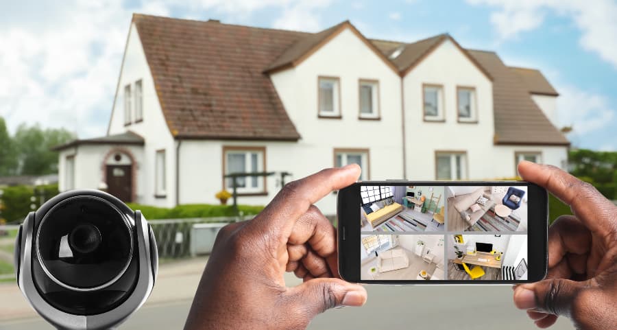 Man holding mobile device and looking at streams from surveillance cameras